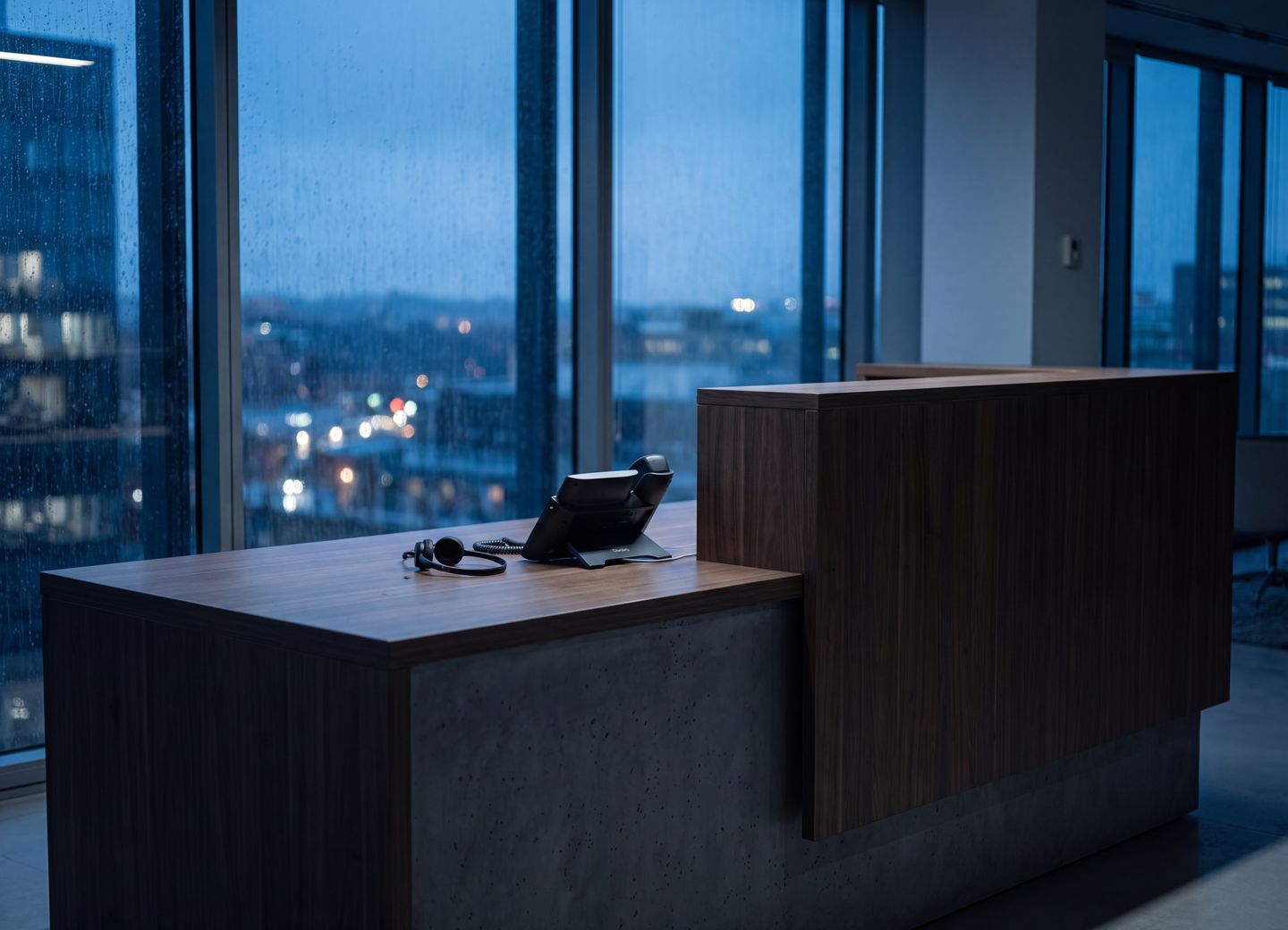 A quiet workspace by a window at night, the city lit beyond